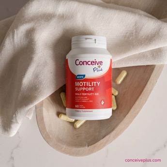 Conceive Plus motility support supplement bottle on a wooden tray with beige cloth