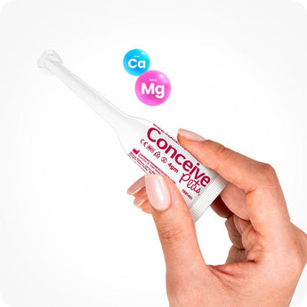 For Conceive Plus Try Me Size Bundle (30ml Tube and 3x4g Applicators), featuring a close-up of a hand holding one 4g pre-filled fertility lubricant applicator, with calcium (Ca) and magnesium (Mg) ion symbols floating above to emphasize fertility-enhancing ingredients, set on a white background.